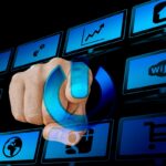 Hand pressing a digital power button on a blue screen, symbolizing automation, smarter traffic systems, and online business efficiency.